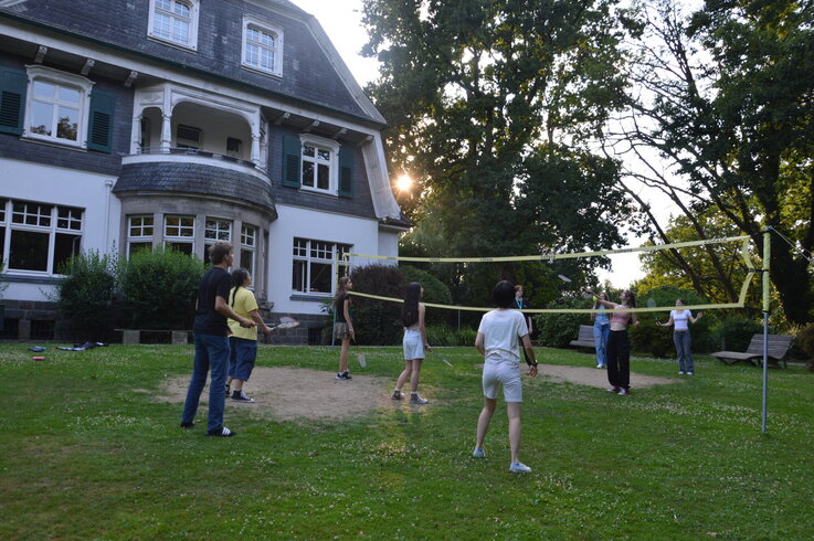 Schüler:innen spielen Volleyball auf einer Wiese